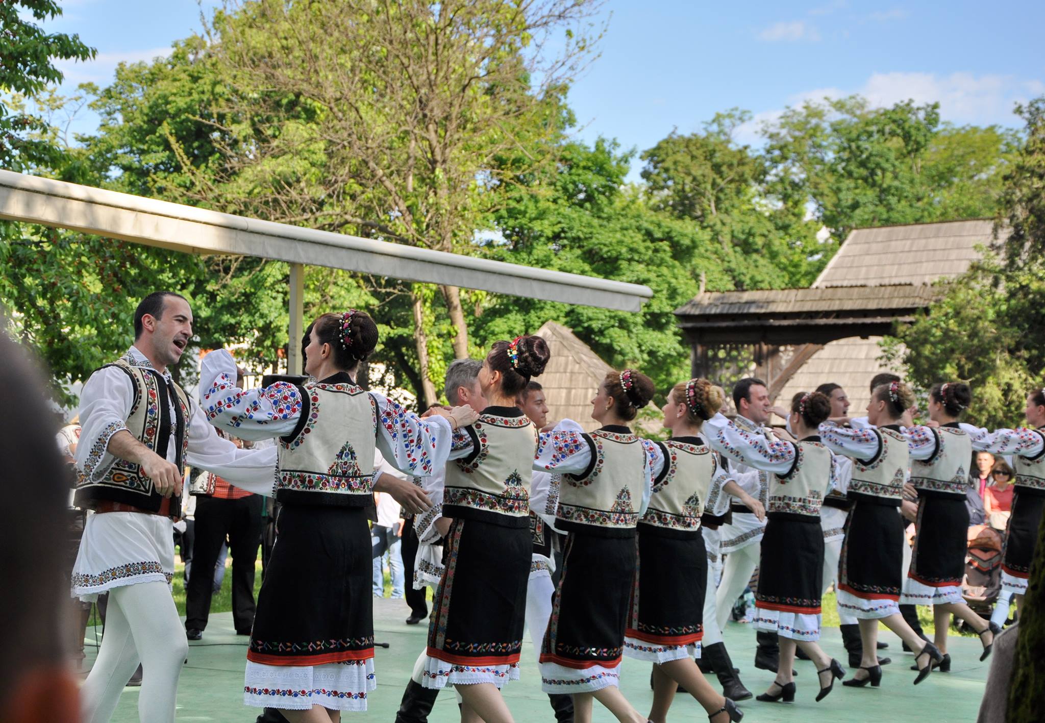 Ansamblul Folcloric Tarabostes interpretând dans popular românesc în aer liber, în costume tradiționale autentice, în cadrul unui eveniment cultural